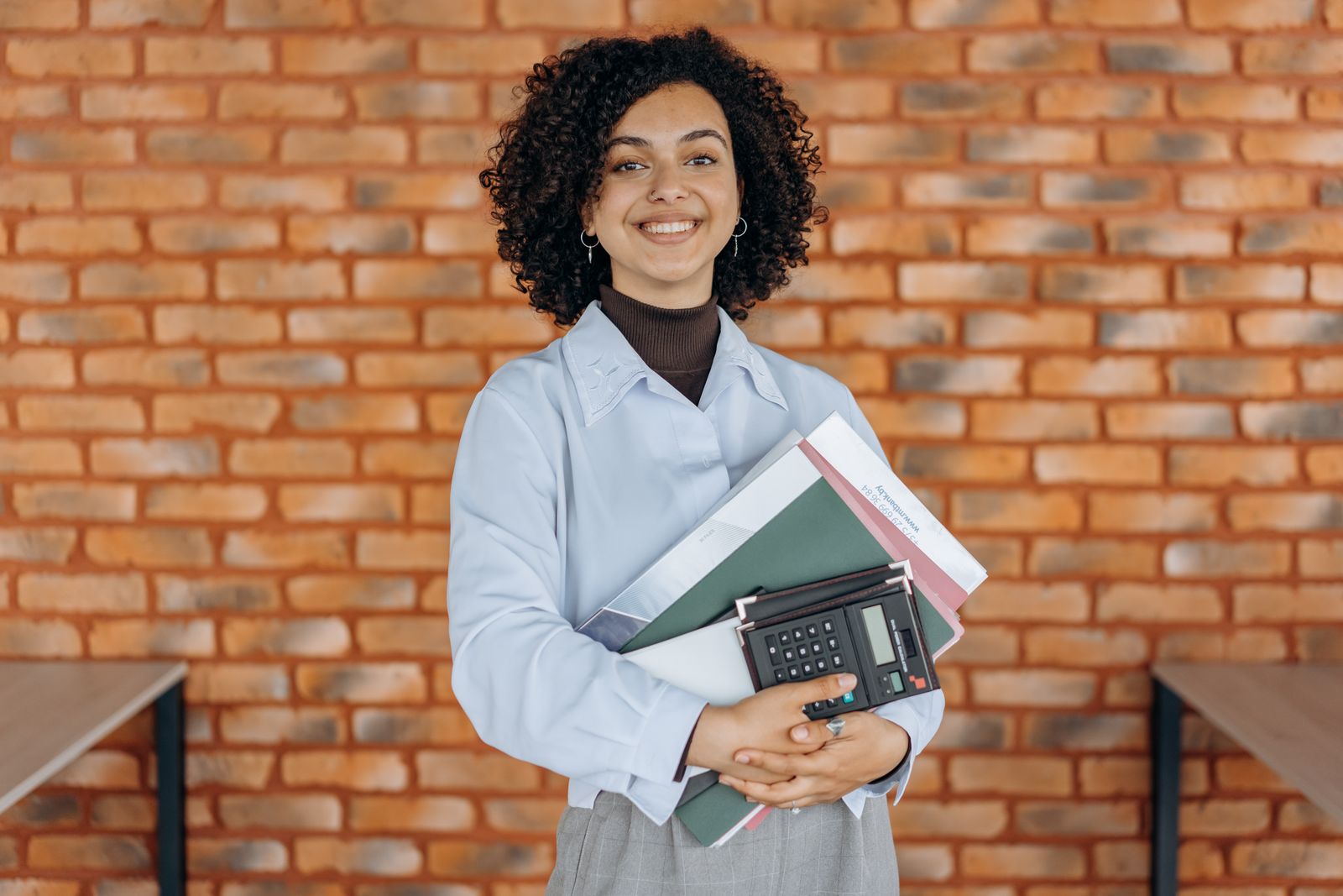 A cheerful bookkeeper holding folders and a calculator