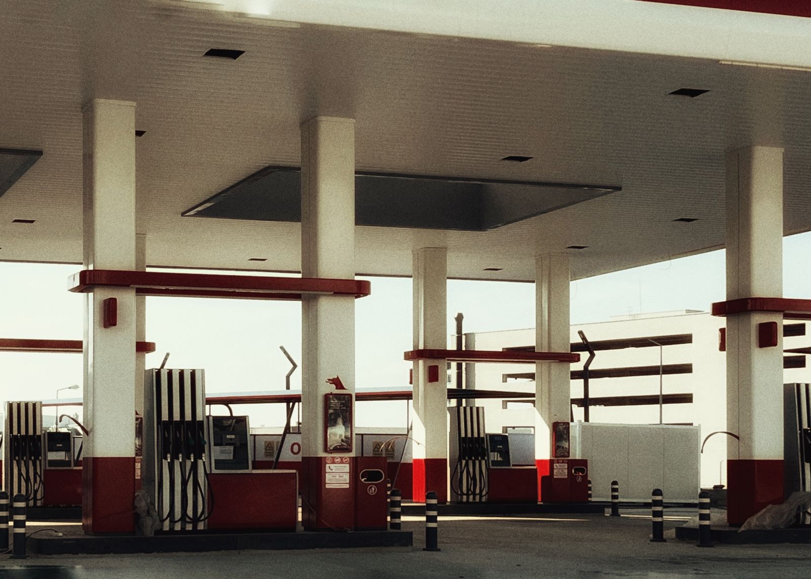 A brightly lit gas station forecourt with a row of fuel pumps