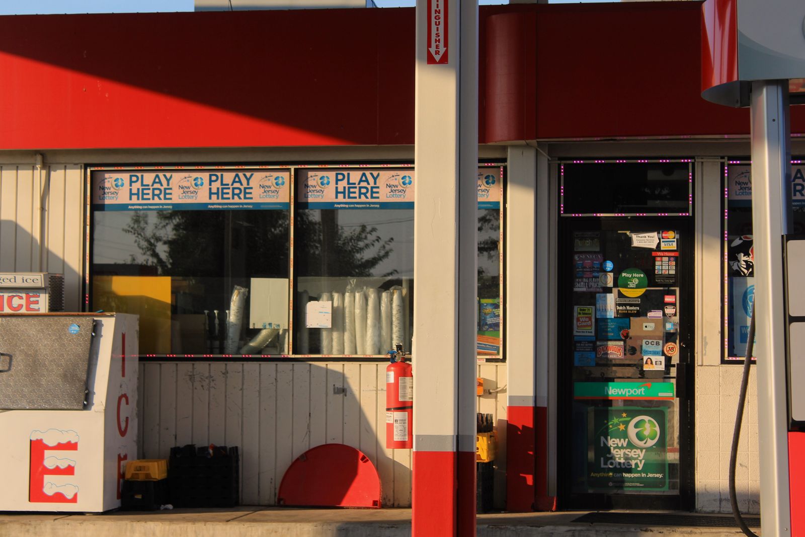 A gas station convenience store entrance with lottery signs
