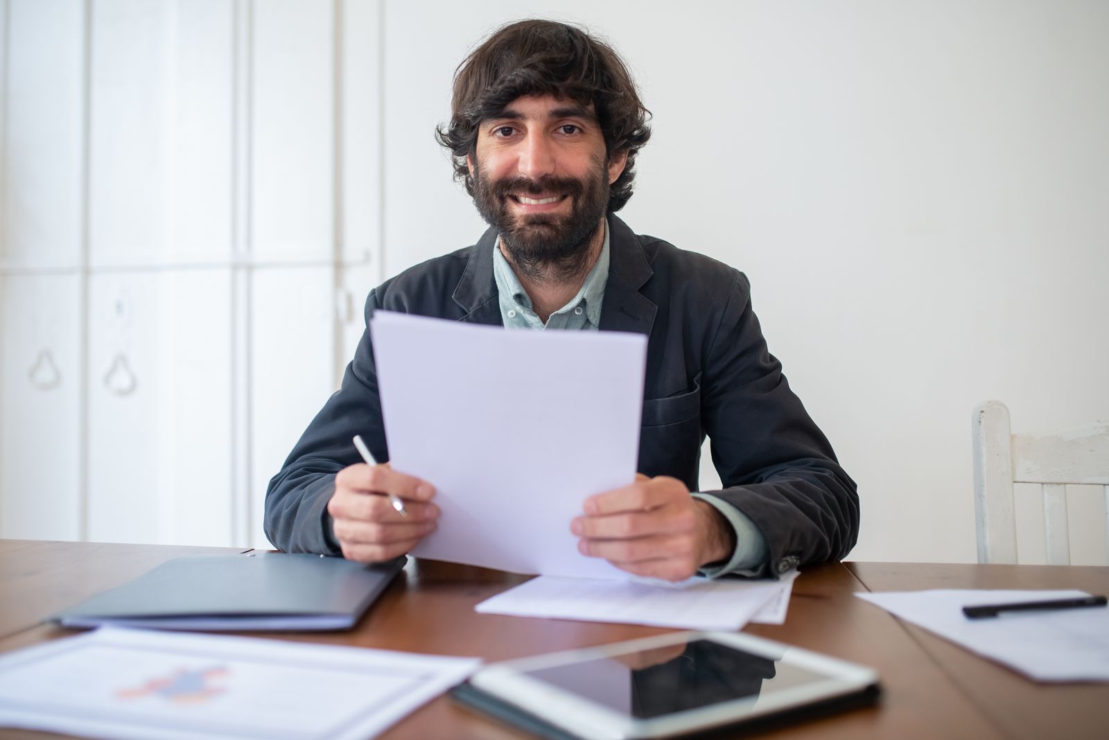 A smiling owner reviewing paperwork at his desk
